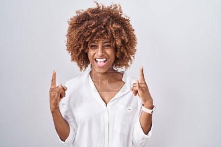 Photo for Young hispanic woman with curly hair standing over white background shouting with crazy expression doing rock symbol with hands up. music star. heavy music concept. - Royalty Free Image