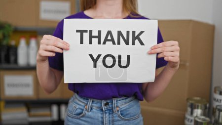 Téléchargez les photos : Jeune femme blonde bénévole tenant un message de remerciement au centre de charité - en image libre de droit