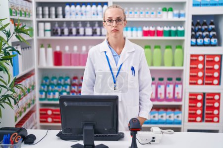 Foto de Young caucasian woman working at pharmacy drugstore depressed and worry for distress, crying angry and afraid. sad expression. - Imagen libre de derechos