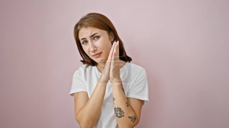 Photo for Young woman doing please gesture with hands together over isolated pink background - Royalty Free Image