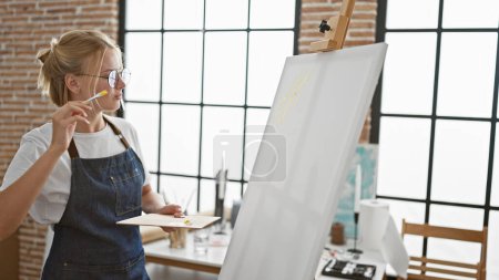 Téléchargez les photos : Jeune femme blonde artiste dessin concentré au studio d'art - en image libre de droit