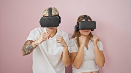 Photo for Beautiful couple playing boxing video game using virtual reality glasses over isolated pink background - Royalty Free Image