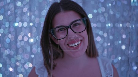 Foto de Una hermosa mujer hispana sonriente con gafas experimenta una exposición de luz futurista en un museo moderno, una exposición de arte inmersivo que genera creatividad y felicidad - Imagen libre de derechos