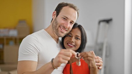Photo for Beautiful couple standing together holding keys at new home - Royalty Free Image