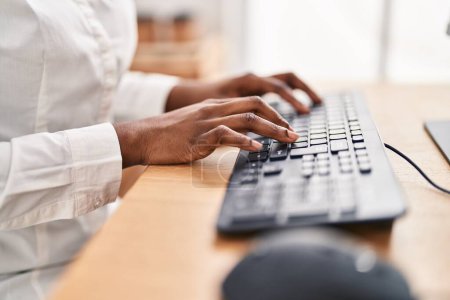 Téléchargez les photos : Femme afro-américaine utilisant un clavier d'ordinateur au bureau - en image libre de droit