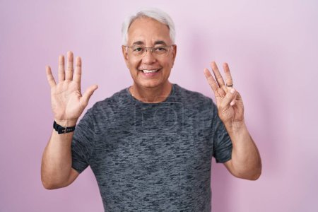 Photo for Middle age man with grey hair standing over pink background showing and pointing up with fingers number eight while smiling confident and happy. - Royalty Free Image