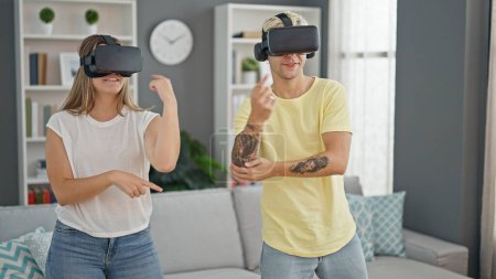 Foto de Hermosa pareja jugando a bailar videojuego usando gafas de realidad virtual en casa - Imagen libre de derechos