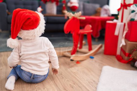 Foto de Adorable bebé caucásico sentado en el suelo por regalos de Navidad en casa - Imagen libre de derechos