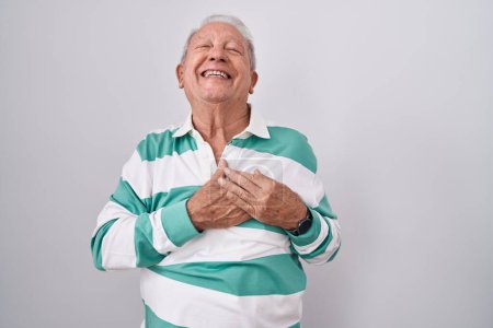 Photo for Senior man with grey hair standing over white background smiling with hands on chest with closed eyes and grateful gesture on face. health concept. - Royalty Free Image