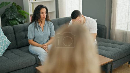Photo for Man and woman sitting on sofa having couple therapy at psychology clinic - Royalty Free Image