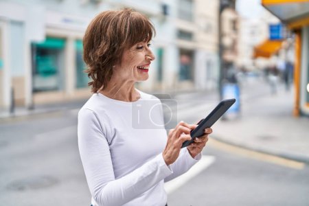 Photo for Middle age woman smiling confident using touchpad at street - Royalty Free Image