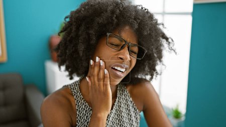 Foto de Trabajadora de negocios afroamericana que sufre de dolor de dientes en la oficina - Imagen libre de derechos