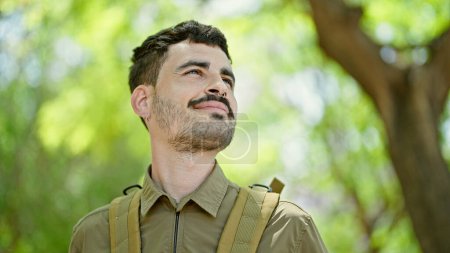 Photo for Young hispanic man tourist wearing backpack smiling at park - Royalty Free Image