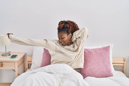 Photo for African american woman waking up stretching arms at bedroom - Royalty Free Image
