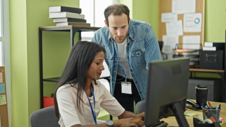Téléchargez les photos : Deux travailleurs homme et femme utilisant l'ordinateur parlant au bureau - en image libre de droit