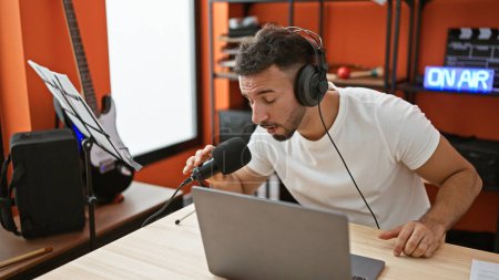 Foto de Joven reportero musical árabe hablando en radio show radio studio - Imagen libre de derechos