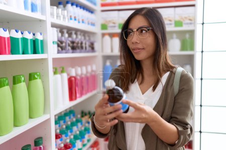Téléchargez les photos : Jeune asiatique femme client lecture médicament bouteille étiquette à pharmacie - en image libre de droit