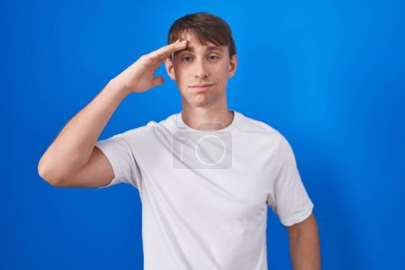 Photo for Caucasian blond man standing over blue background worried and stressed about a problem with hand on forehead, nervous and anxious for crisis - Royalty Free Image