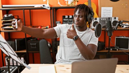 Téléchargez les photos : Africain américain musicien faire selfie par smartphone faire pouce vers le haut geste au studio de musique - en image libre de droit