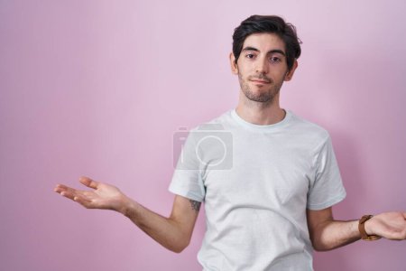 Photo for Young hispanic man standing over pink background clueless and confused with open arms, no idea concept. - Royalty Free Image