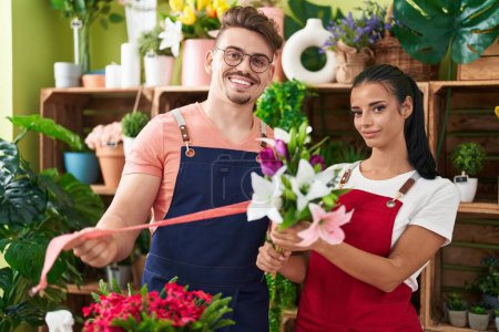 Téléchargez les photos : Fleuristes hommes et femmes tenant bouquet de fleurs et dentelle cadeau à la boutique de fleurs - en image libre de droit