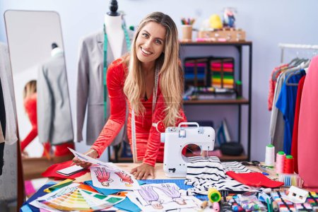Téléchargez les photos : Jeune femme blonde tailleur souriant confiant design de vêtements à la boutique de tailleur - en image libre de droit
