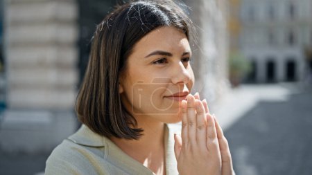 Photo for Young beautiful hispanic woman smiling praying at cafeteria - Royalty Free Image