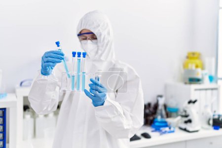 Photo for Young blonde woman scientist wearing security uniform holding test tubes at laboratory - Royalty Free Image
