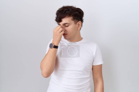 Foto de Hombre joven no binario con camiseta blanca casual cansado frotando la nariz y los ojos sintiendo fatiga y dolor de cabeza. concepto de estrés y frustración. - Imagen libre de derechos