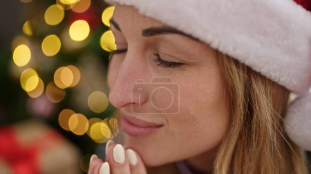 Téléchargez les photos : Jeune belle femme hispanique priant assis près de l'arbre de Noël à la maison - en image libre de droit