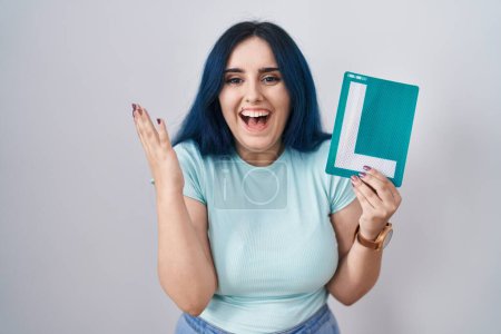 Photo for Young modern girl with blue hair holding l sign for new driver celebrating victory with happy smile and winner expression with raised hands - Royalty Free Image