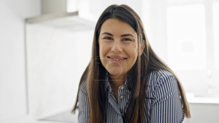 Téléchargez les photos : Jeune belle femme hispanique souriant heureux à la cuisine - en image libre de droit