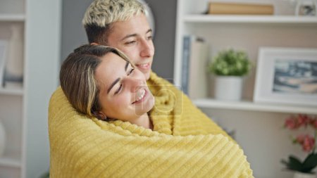 Téléchargez les photos : Beau couple couvrant avec couverture étreignant l'autre à la maison - en image libre de droit
