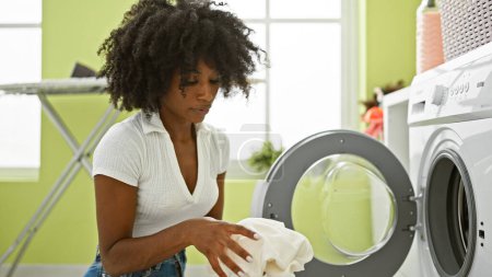 Foto de Mujer afroamericana lavando ropa en la lavandería - Imagen libre de derechos