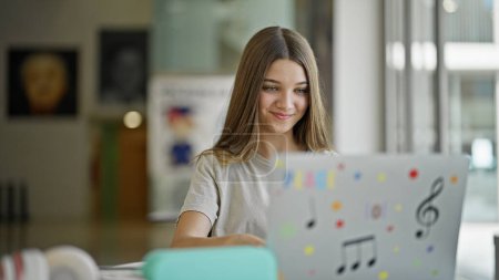 Photo for Young beautiful girl student using laptop studying at library - Royalty Free Image