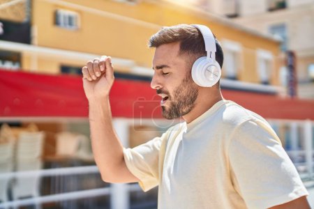 Foto de Joven hispano escuchando música y bailando en la calle - Imagen libre de derechos