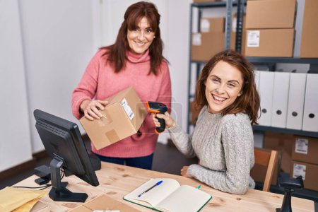 Foto de Two women ecommerce business workers scanning package at office - Imagen libre de derechos