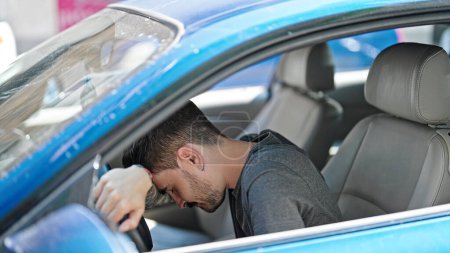 Photo for Young hispanic man driving car stressed at street - Royalty Free Image