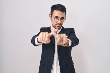 Foto de Hombre hispano de negocios guapo parado sobre fondo blanco expresión de rechazo cruzando dedos haciendo signo negativo - Imagen libre de derechos