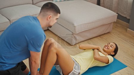 Photo for Beautiful couple happily training abs exercise together at home - Royalty Free Image