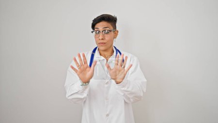 Photo for Young beautiful hispanic woman doctor standing with serious expression doing calm gesture over isolated white background - Royalty Free Image