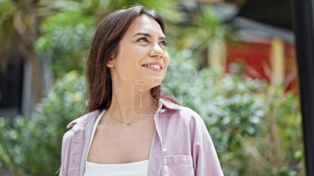 Téléchargez les photos : Young beautiful hispanic woman smiling confident looking to the sky at park - en image libre de droit