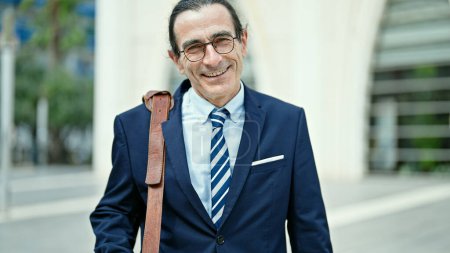 Téléchargez les photos : Homme d'âge moyen homme d'affaires travailleur souriant confiance debout dans la rue - en image libre de droit