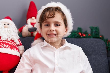 Photo for Adorable hispanic boy smiling confident sitting on sofa by christmas decoration at home - Royalty Free Image