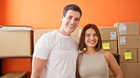 Foto de Dos trabajadores hombre y mujer de pie juntos sonriendo en la oficina - Imagen libre de derechos