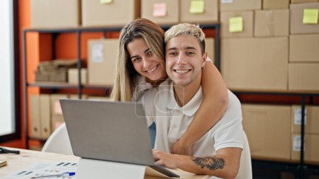 Photo for Two workers man and woman using laptop hugging at office - Royalty Free Image