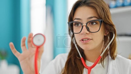 Téléchargez les photos : Jeune belle hispanique femme médecin examen avec stéthoscope à la clinique - en image libre de droit