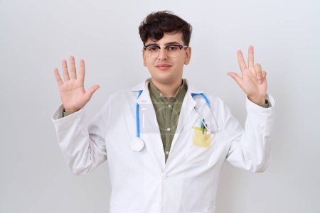 Photo for Young non binary man wearing doctor uniform and stethoscope showing and pointing up with fingers number eight while smiling confident and happy. - Royalty Free Image