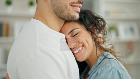 Foto de Hombre y mujer pareja abrazándose sonriendo en casa - Imagen libre de derechos