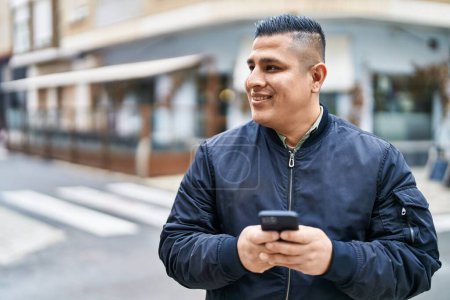 Photo for Young latin man smiling confident using smartphone at coffee shop terrace - Royalty Free Image
